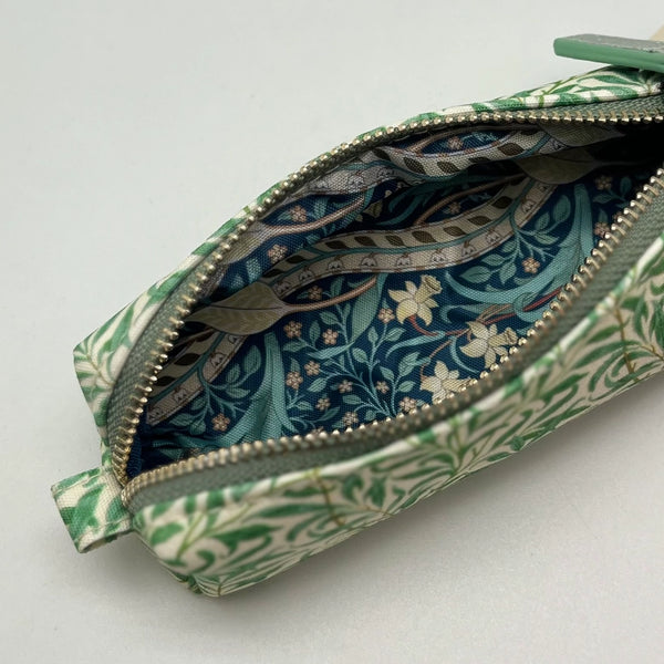 Green floral-patterned pouch with a zipper on a light gray background