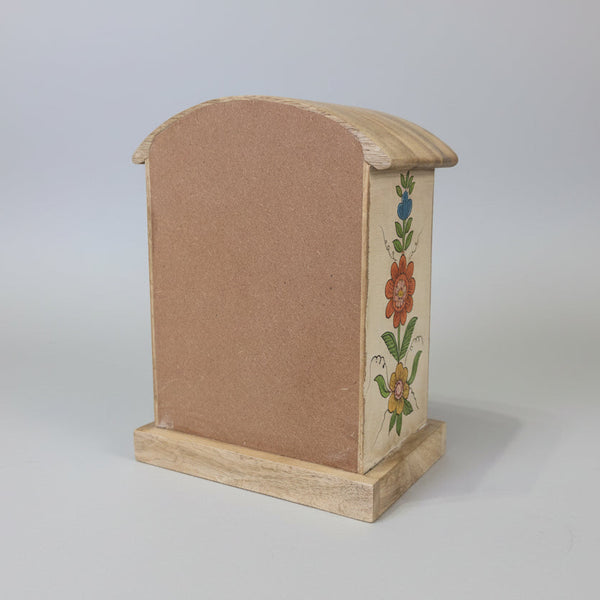 Wooden box with floral designs on a plain background