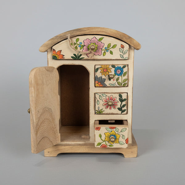 Wooden chest of drawers with floral designs on a gray background