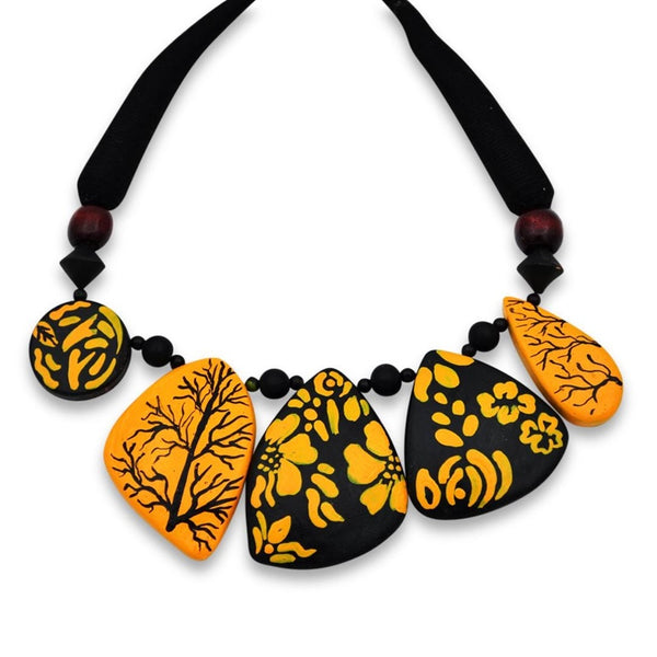 Necklace with orange and black leaf-shaped beads on a white background