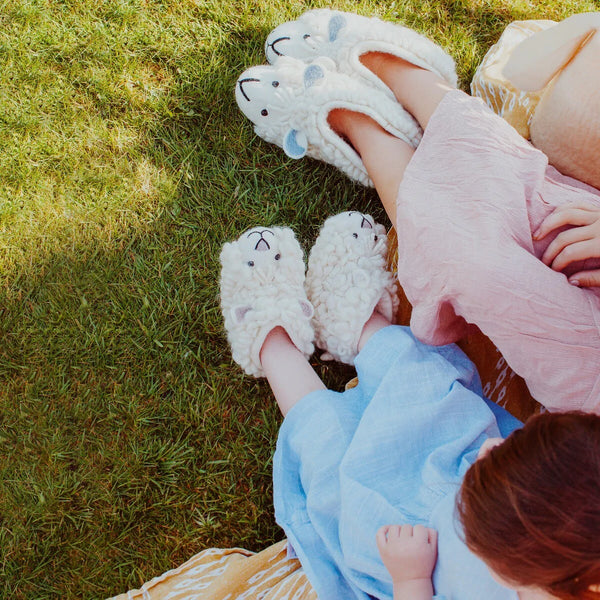 Shirley Sheep and Sherry Sheep Adult and Children's felted handmade slippers modelled on a lady and little girl who are sitting outside in the sunshine