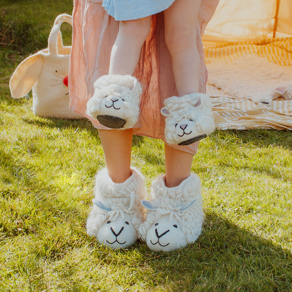 Handmade felted sheep slippers modelled by an adult and a child